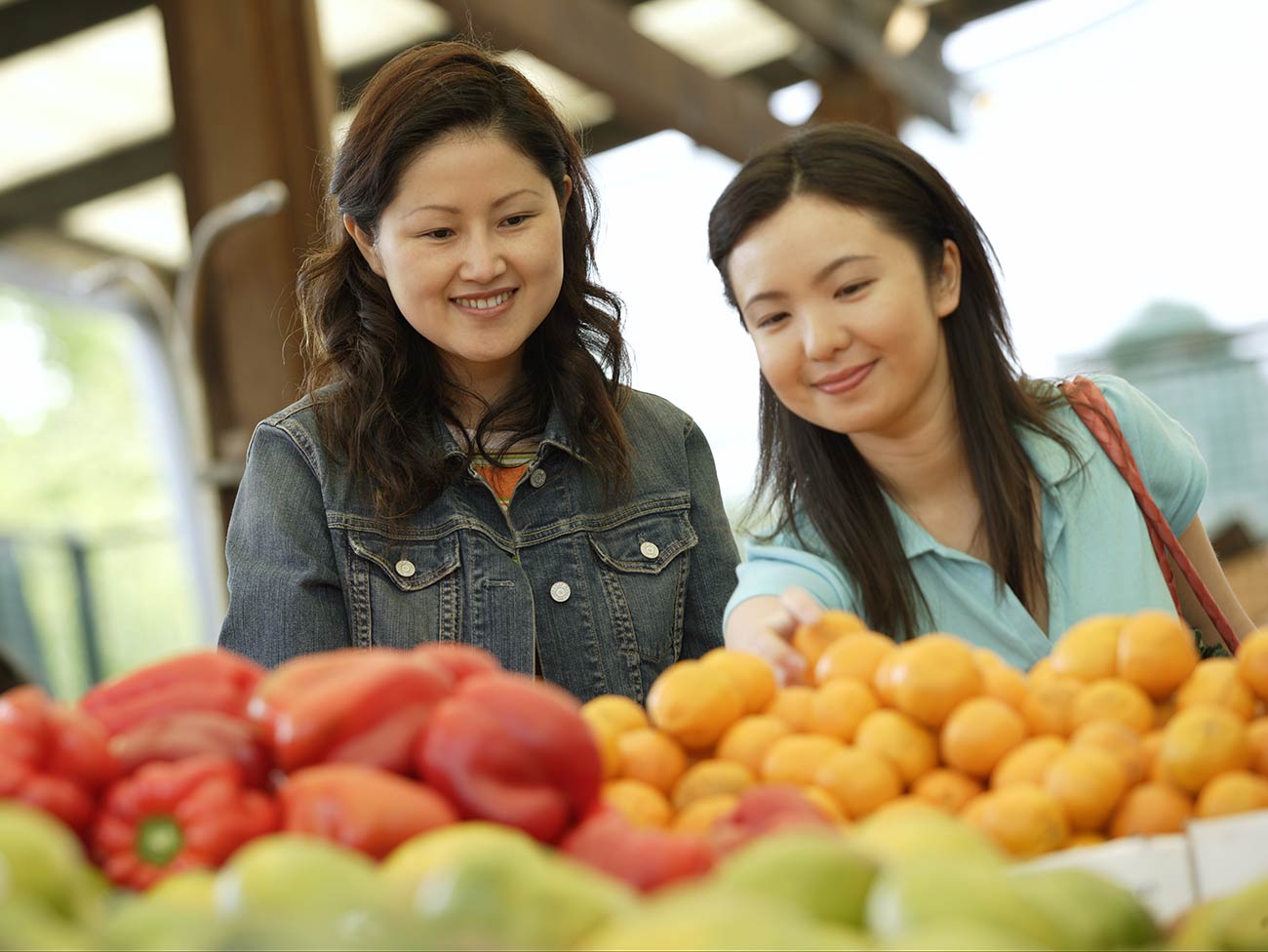 2 women selecting fruit at a farmers market