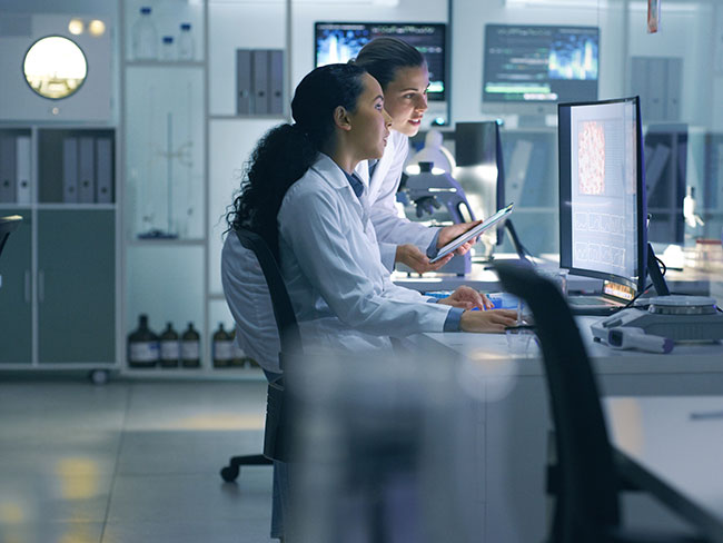 2 women scientists look at a computer