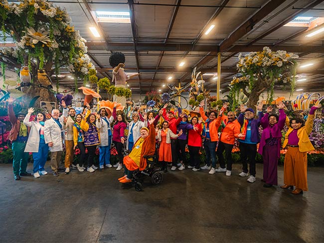 group photo of participants standing in front of float