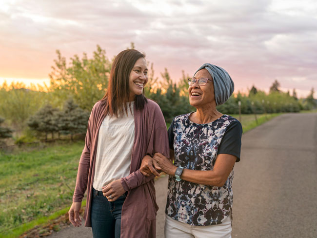 mixed mother and daughter walking outdoors