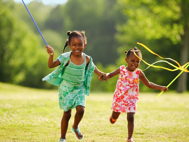 Two young girls running and smiling 