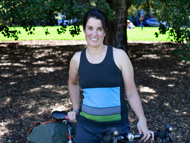 woman standing outdoors with bicycle 