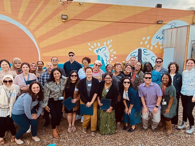 group photo of people standing together outside and smiling