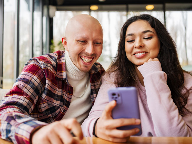 Two people looking at a mobile phone