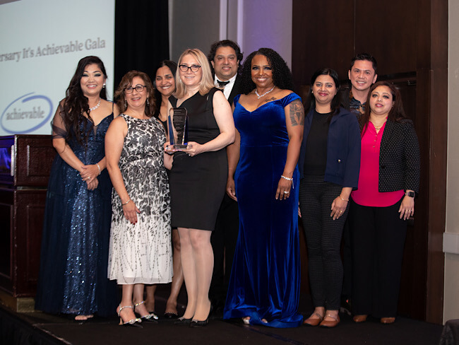 A group of individuals posing for a photo at an awards gala.