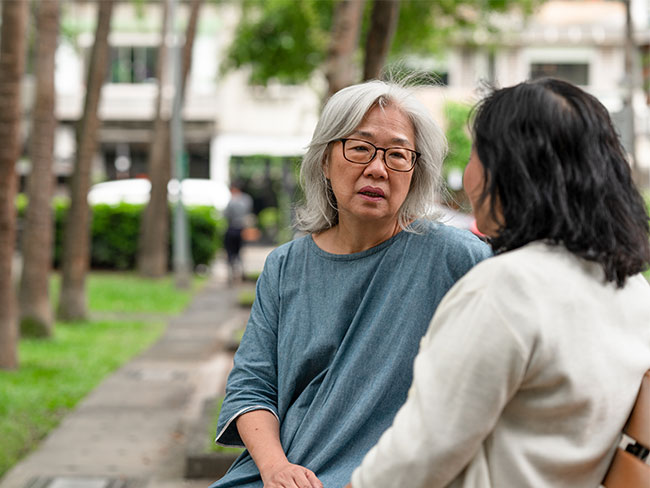 Asian women talking a bench