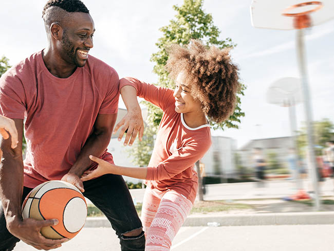 Father and daughter playing basketball