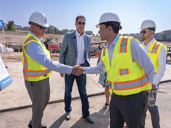 men greeting each other at groundbreaking construction site