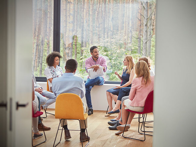 A group of people sitting in a circle talking.