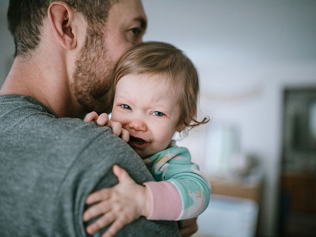 Father holding sick daughter