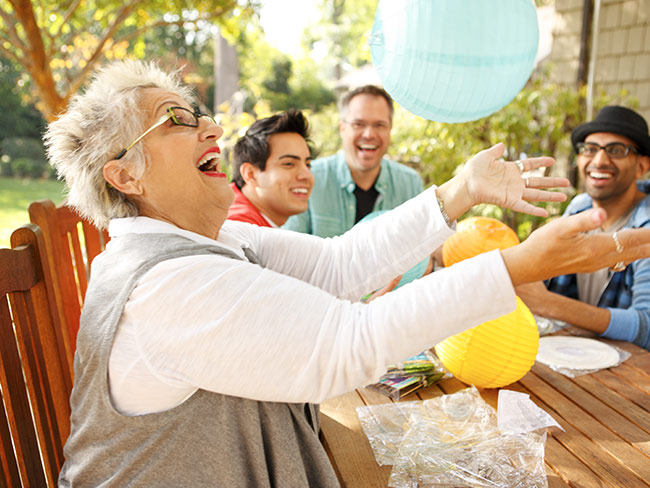 Senior woman enjoying an outdoor party with friends.