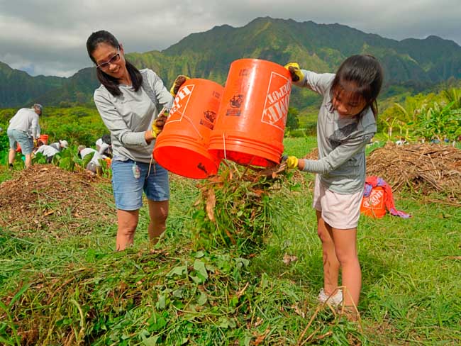 Mother and daughter dumping weeds.