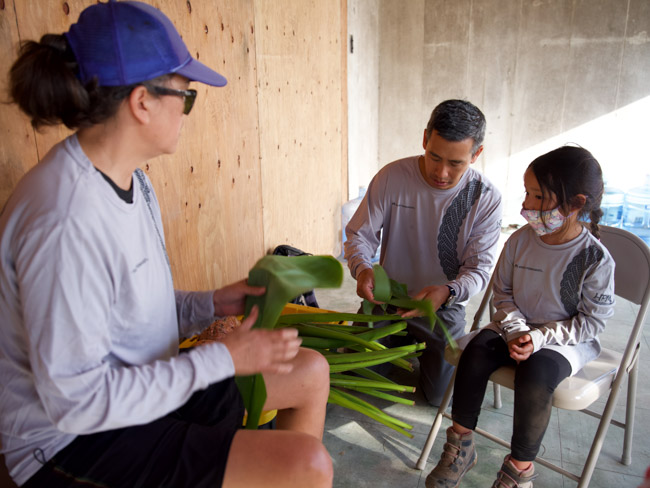 Volunteers work with ti leaves.