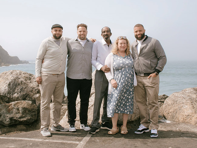 Jones family standing by the ocean.