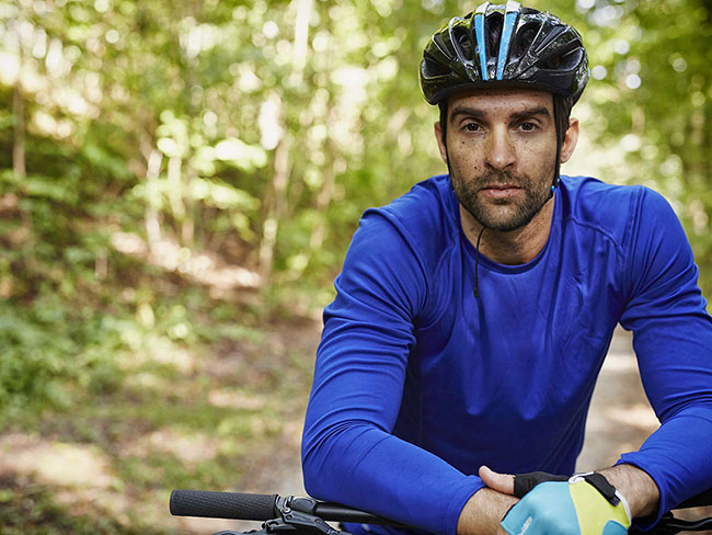 Man with muddy face on bicycle