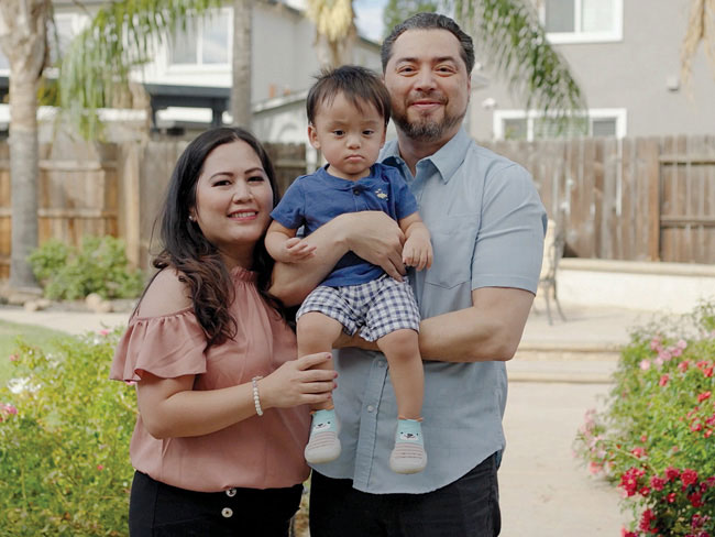 Maria Cobos and her family, as father is holding the baby and Maria right next to them