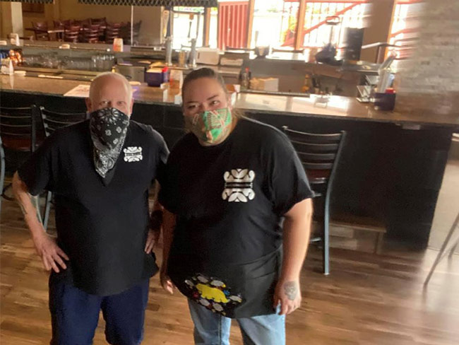 Restaurant workers standing in front of counter. 