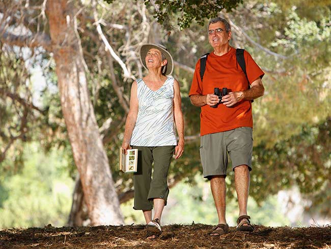 Senior couple bird watching outdoors