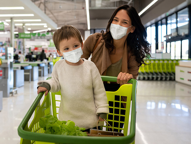 Mother pushing her son in a shopping cart