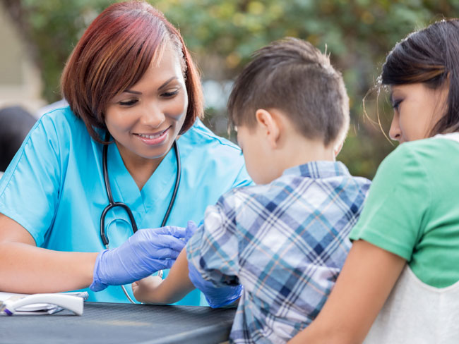 nurse giving vaccination shot to young boy