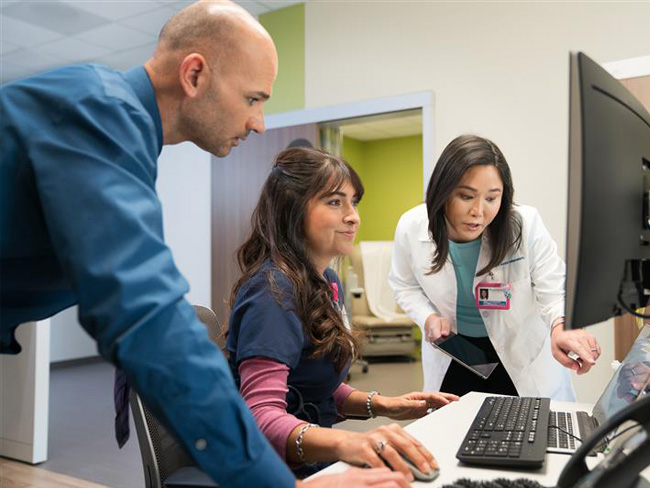 Nurses working together with a physician at a computer