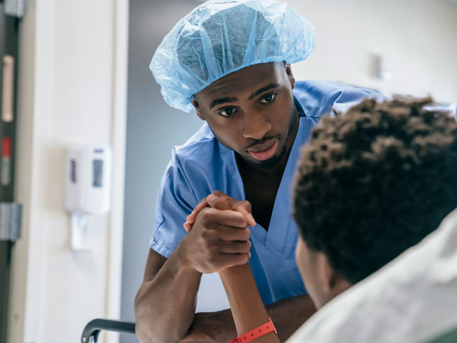 medical worker dressed in scrubs holding the hand of a patient in a hospital