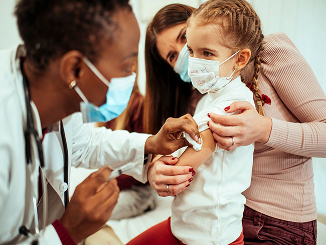 Doctor prepares to give a child a shot.