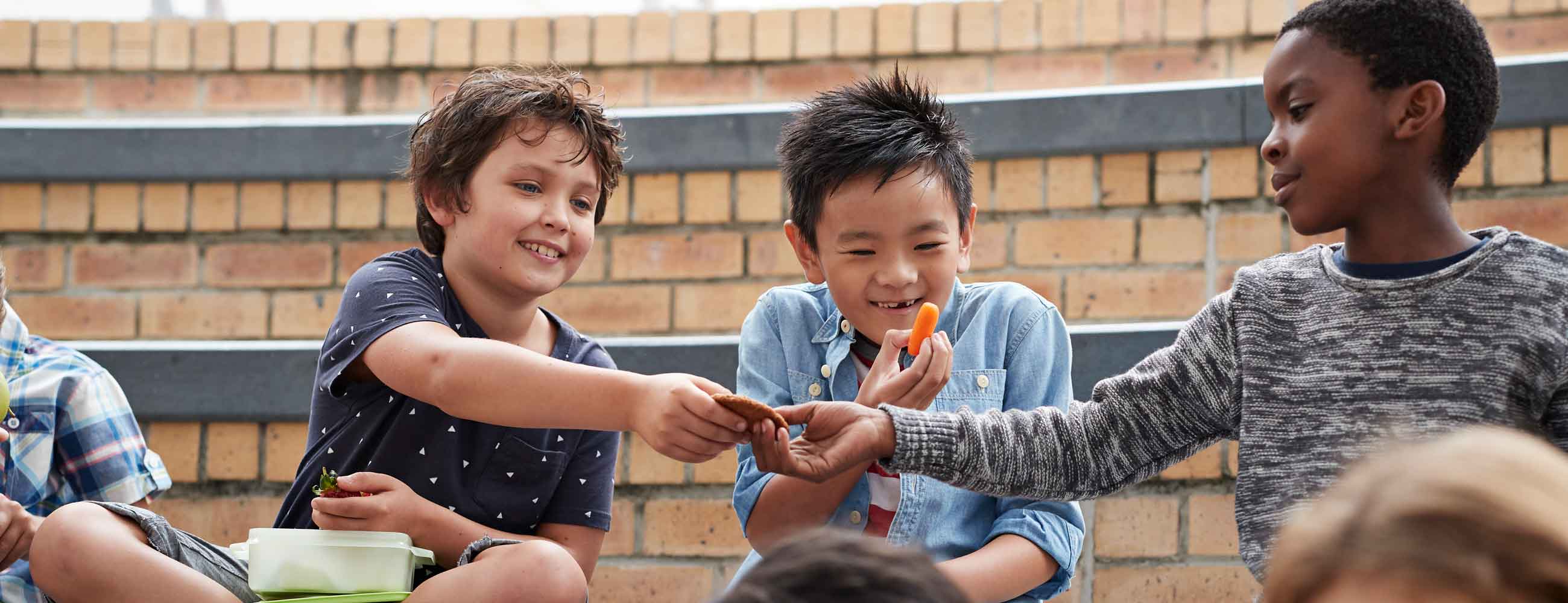 School children having lunch together outside the building 