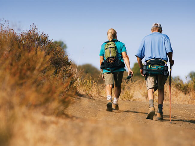 Two people hiking outside on a sunny day.