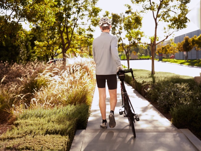 Man walking with bicycle on a sidewalk