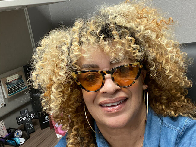 Carolyn Henderson smiling seated at office desk