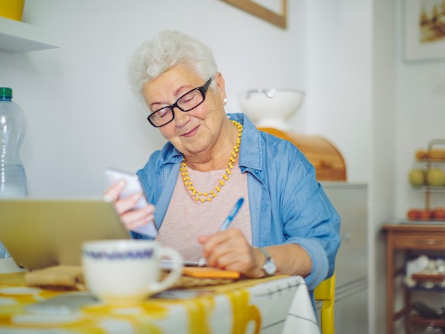 Elderly woman writing at the table