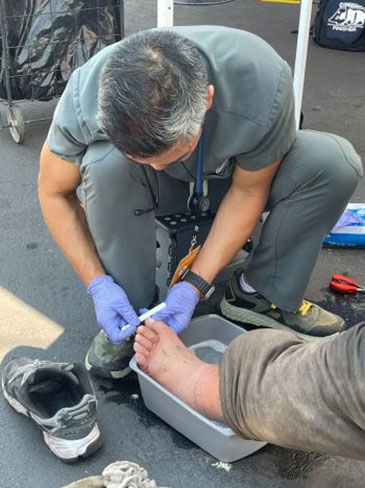 Dr. Leung bending down to examine a persons foot