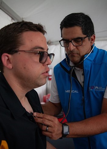 A physcian checks a patient's heart with a stethoscope. 