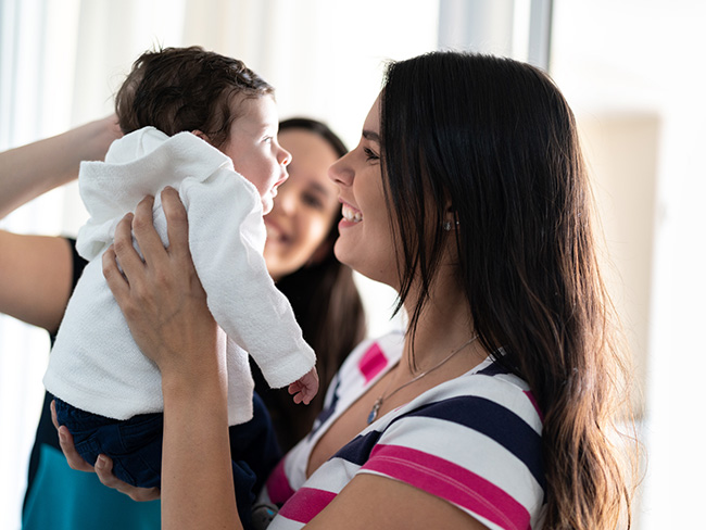 woman holding up a newborn baby