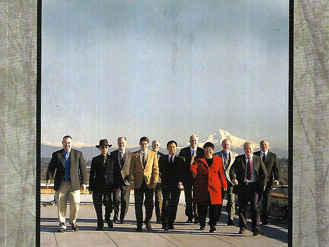 A line of business people walking, with a snow-covered mountain in the distance behind them.