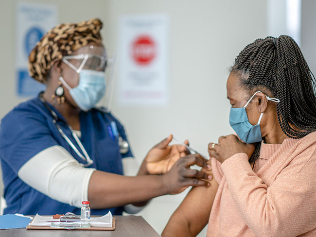 A senior female is receiving her COVID-19 vaccine at the hospital