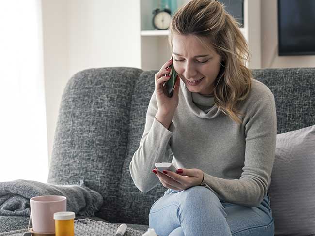 Young woman checking glucose level  and Video chatting With her Doctor at home.