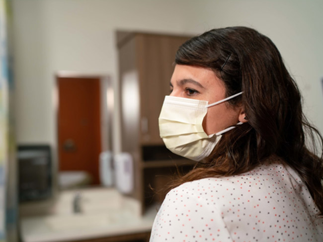 Woman wearing a mask looking left. 