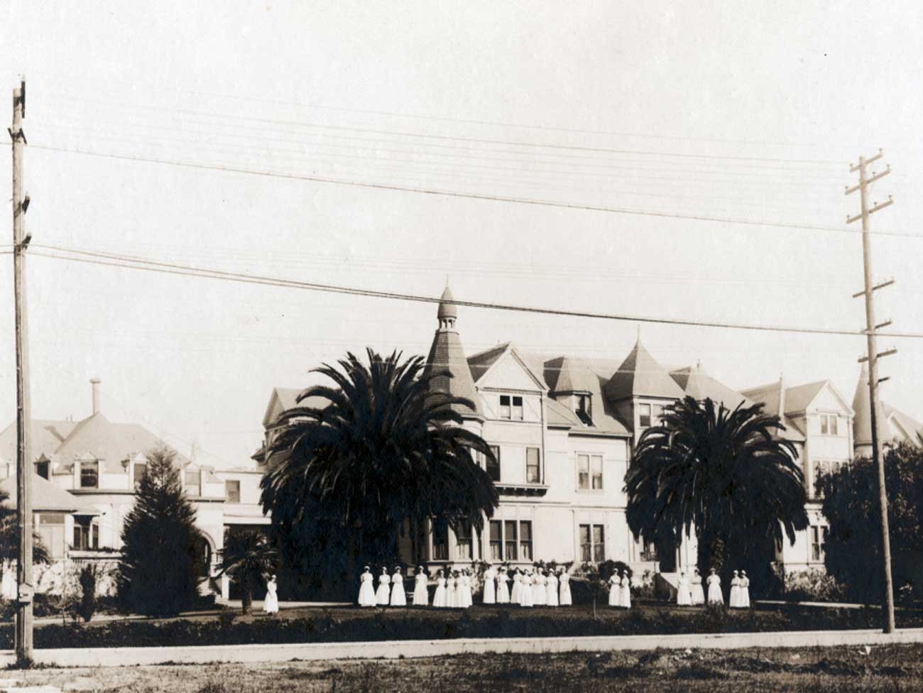 Black and white photo of hospital with staff standing in front