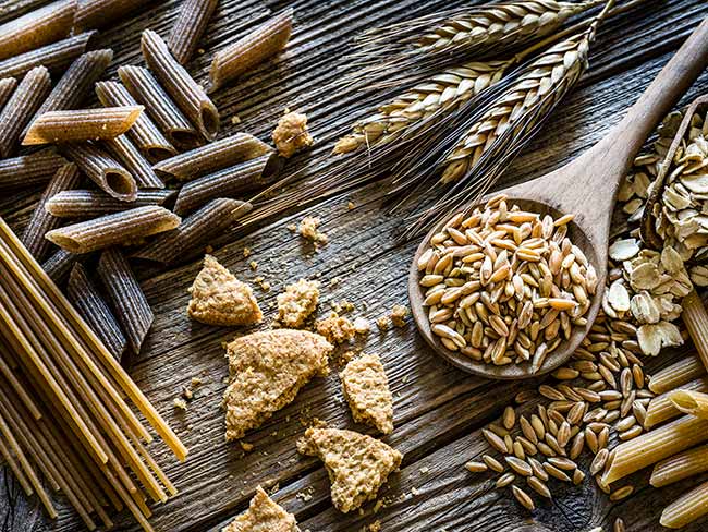 Spelt, oat flakes and wholegrain pasta on rustic wooden table