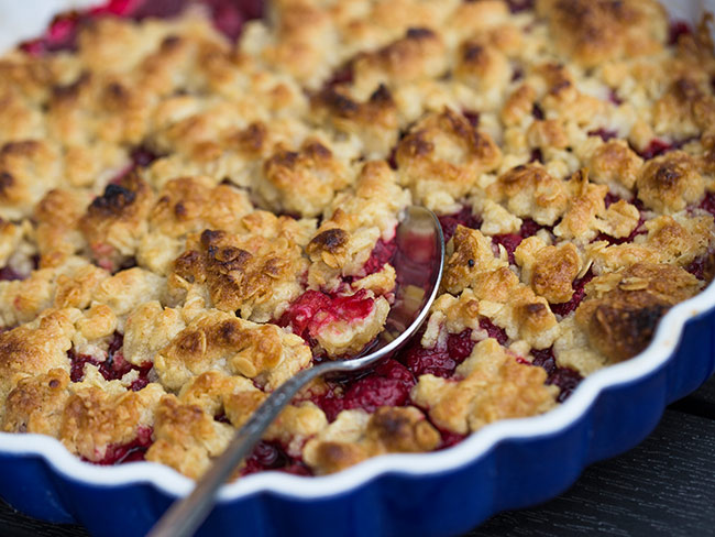 Fresh strawberry pie topped with graham cracker crumbs in a blue baking dish.