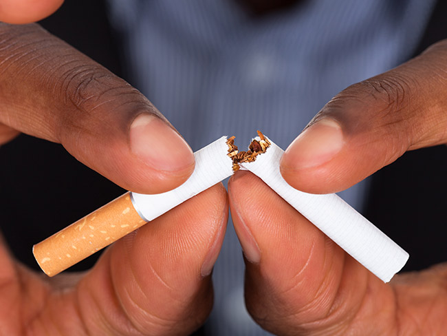 Hands breaking a cigarette in half