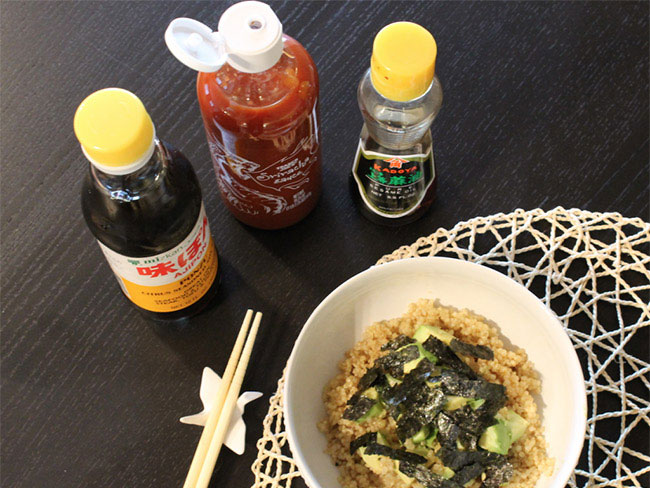 Asian-inspired quinoa bowl served with hot sauce soy sauce and chopsticks