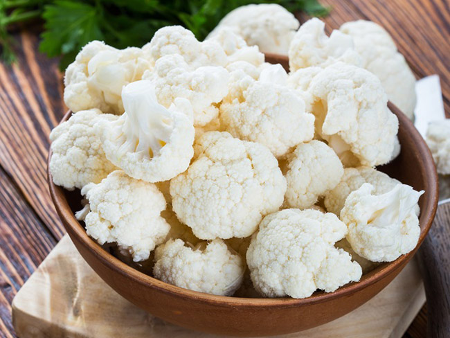 Cauliflower florets in a wooden bowl