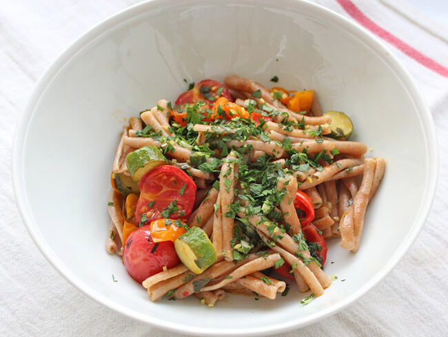 Cherry tomato pasta with gremolata served in a white plate