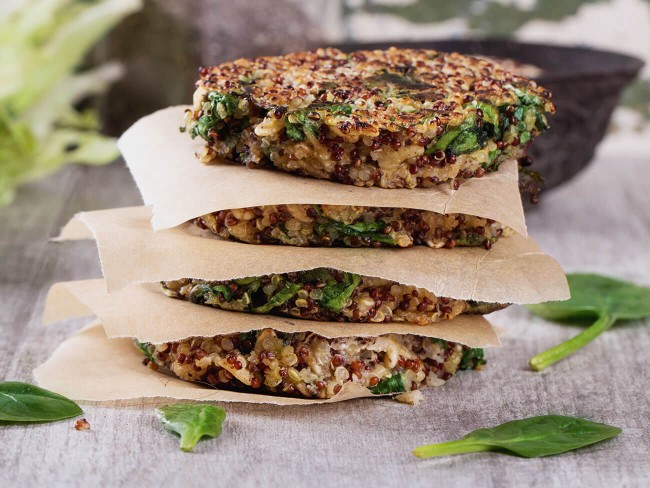 Quinoa patties stacked on top of each other with parchment paper in between