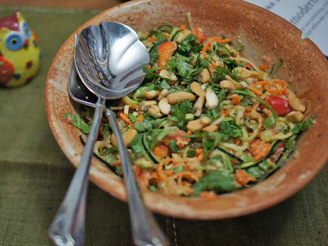 Raw Thai citrus salad with zucchini in an earthen bowl.