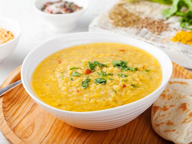 A bowl of lentil soup with pita bread