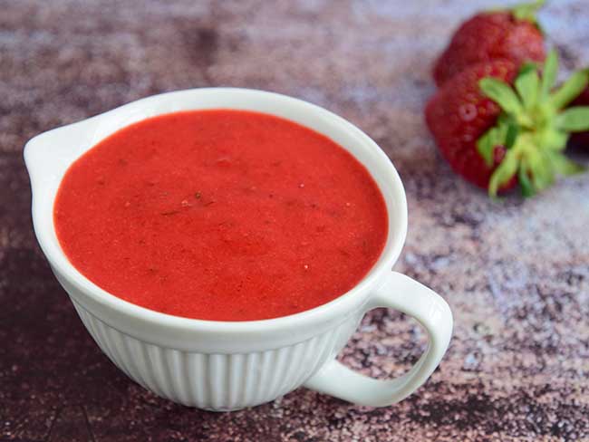 Homemade strawberry dressing with fresh strawberries on the side.